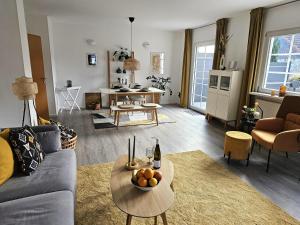 a living room with a couch and a bowl of fruit on a table at Landhaus SoonZauber - Exklusives Paar-Hideaway im Naturpark Soonwald-Nahe in Münchwald +33 photos