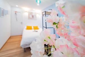 a room with a bed and pink flowers at Paris - Blue Sky Homestay in Le Kremlin-Bicêtre