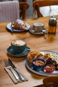 a table with two cups of coffee and a plate of food at The Bottle & Glass Inn - Barn View - Room 2 in Henley on Thames +9 photos