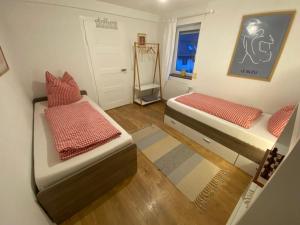 a small bedroom with two beds and a window at Ferienwohnung Eberhard in Schwäbisch Gmünd