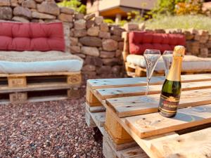 a bottle of champagne and glasses on a wooden table at Gîte Origin Gueberschwihr in Gueberschwihr