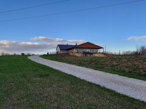a house on a field with a gravel road at Country Resort in Bates City