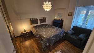 a bedroom with a bed and a couch and a chandelier at Casa Bomba in San Mauro Torinese