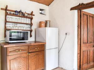 a kitchen with a white refrigerator and a microwave at Stable Cottage in Windermere
