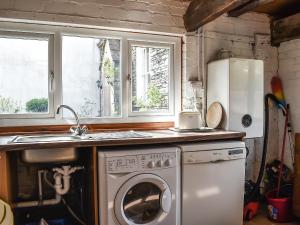 a kitchen with a sink and a washing machine at Stable Cottage in Windermere +12 photos