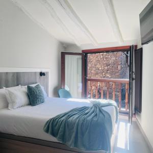 a bedroom with a bed and a large window at Casa Briz in Ojedo