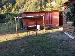 a shed with a chair in front of a house at Cabañas Donde Nancy in Hornillos +12 photos