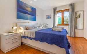 a bedroom with a large bed with a blue blanket at Good choice in Valbandon