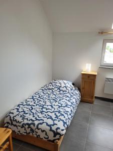 ein kleines Schlafzimmer mit einem Bett und einem Tisch in der Unterkunft Apartment Libramont in Libramont