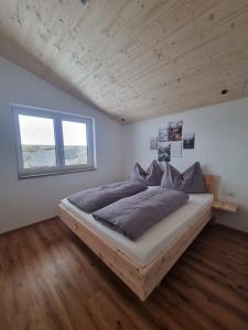 a bedroom with a large bed in a room with wooden ceilings at Ferienwohnung Kogler Zillertal in Fügenberg