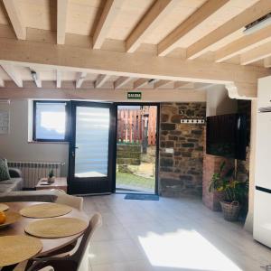 a living room with tables and chairs and a door at Casa Briz in Ojedo