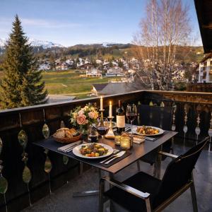 a table with food and wine on a balcony at Casa Ladina 4 in Falera