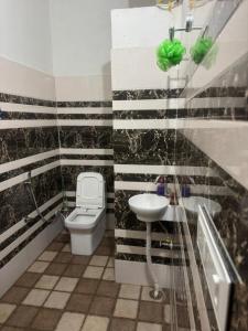 a bathroom with a toilet and a sink at deephotel in Chhorang