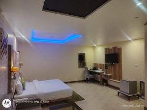 a room with a bed and a desk with a computer at deephotel in Chhorang