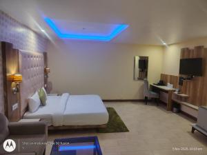 a hotel room with a bed and a desk and a television at deephotel in Chhorang