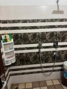 a shower in a bathroom with black and white stripes at deephotel in Chhorang