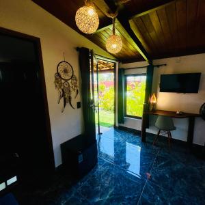 a living room with a television and a table and a window at Kitesurf Oasis Maracajaú in Maracajaú
