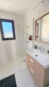 a white bathroom with a sink and a shower at Les Oliviers climatisés parking recharge électrique in Arles +28 photos