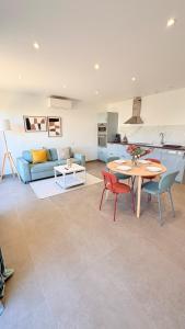 a living room with a table and chairs and a couch at Les Oliviers climatisés parking recharge électrique in Arles