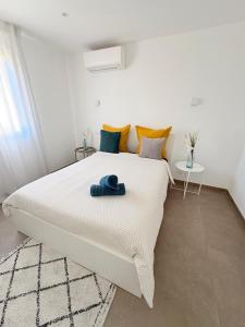 a bedroom with a white bed with a blue towel on it at Les Oliviers climatisés parking recharge électrique in Arles