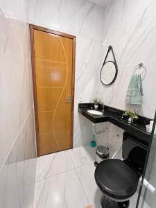 a bathroom with a black toilet and a mirror at Chalé de Serra 02 em Viçosa do Ceará in Viçosa do Ceará +8 photos