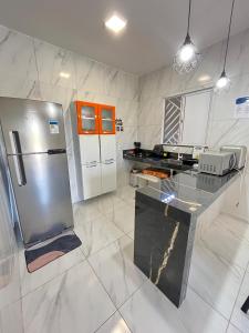 a kitchen with a stainless steel refrigerator and appliances at Chalé de Serra 02 em Viçosa do Ceará in Viçosa do Ceará