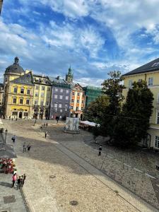 un gruppo di persone che camminano in una città con edifici di Hotel 39 a Lviv