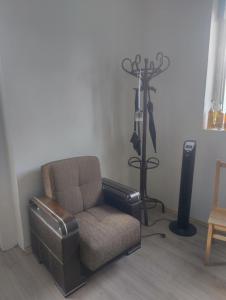 a living room with a chair and a fan at Edle Tropfen in Tqibuli