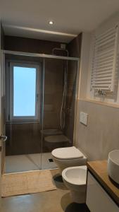 a bathroom with a shower and a toilet and a window at Moro 70 locazione turistica in Montanes