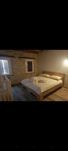 a bedroom with a large bed and a brick wall at Moro 70 locazione turistica in Montanes