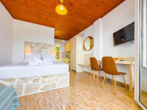 a bedroom with a bed and a table and chairs at The Life Suites in Limnionas