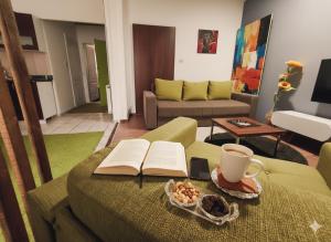 a living room with a table with a book and a cup of coffee at Fast Sleep & Go 1 in Paraćin