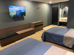 a bedroom with a bed and a tv on the wall at Hotel Le-Gar in Monterrey