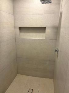 a bathroom with a shower with a tile floor at Hotel Le-Gar in Monterrey