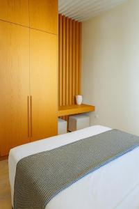 a bedroom with a bed and a wooden cabinet at The Village by WPS in Pollonia