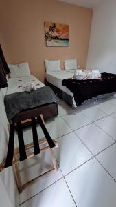 a room with two beds and a chair in it at Caminho do Paraíso in Porto De Galinhas