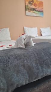 a stuffed animal is laying on a bed at Caminho do Paraíso in Porto De Galinhas