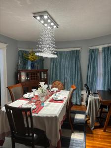 a dining room with a table and a chandelier at Eden's Lodge in East Hartford