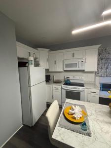 a kitchen with a white refrigerator and a table with a plate on it at Eden's Lodge in East Hartford +19 photos