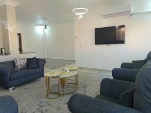 a living room with two blue couches and a table at شقق العون in Jerash