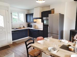 a kitchen with black cabinets and a wooden table at Ernest Lodge Angers in Angers
