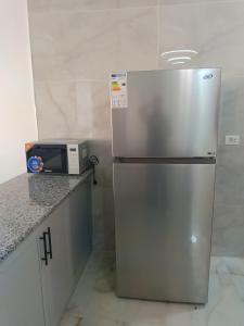 a stainless steel refrigerator in a kitchen with a microwave at شقق العون in Jerash