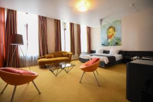 a hotel room with a bed and two chairs at Hotel d'Alcantara in Tournai