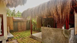 a house with a straw roof and a yard at Villa Isleñas - Solar, Starlink, Pool in General Luna