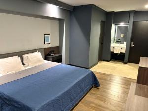 a bedroom with a blue bed and a bathroom at Hotel Le-Gar in Monterrey +13 photos