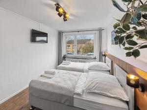 two beds in a room with a window at charmantes Apartment bei Hamburg - Ruhe, Komfort & kostenloses Parken in Rellingen