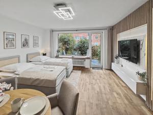 a hotel room with two beds and a television at charmantes Apartment bei Hamburg - Ruhe, Komfort & kostenloses Parken in Rellingen