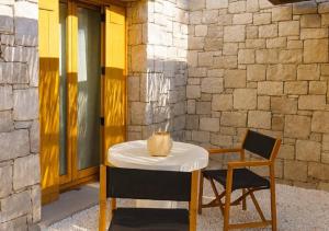 a table and chair with a vase on top of it at The Village by WPS in Pollonia