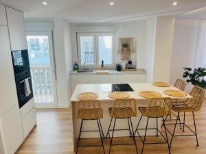 a kitchen with a table and stools in a room at RÍA LIVING - Calma 02 in Cee