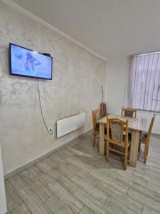 a dining room with a table and a tv on the wall at Konak Kod Gorana 1 in Subotica
